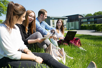 Gruppe Studierender sitzend auf der Wiese auf dem Campus Wilhelmshaven